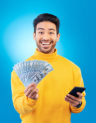 Image showing Man, phone and cash fan in studio for prize, esports gambling or excited in portrait by blue background. Young asian guy, winner and smartphone for money, fintech or crypto with profit, bonus or goal