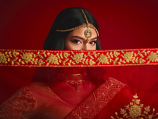 Image showing Fashion, eyes and portrait of Indian woman with veil in traditional clothes, jewellery and sari. Religion, beauty and female person on red background with accessory, cosmetics and makeup for culture