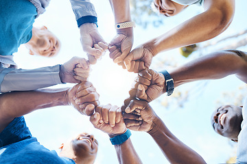 Image showing Fist bump, fitness and group of people for teamwork, collaboration and community, team building and support. Mission, workout goals and hands, power and solidarity sign of person outdoor from below