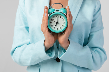 Image showing Woman holding clock in the hand