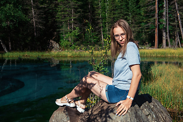 Image showing Woman resting at mountain lake in summer