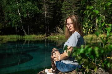 Image showing Woman resting at mountain lake in summer