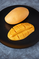 Image showing Fresh yellow mango fruit in a black plate