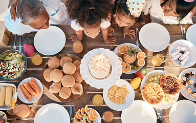 Image showing Birthday, party and family with top view with food or children for celebration and eating cake for milestone. Party, parents and kid is blowing dessert on table with feast or joy for special event.