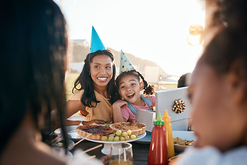 Image showing Family, outdoor and mother with girl, birthday and celebration with happiness, excited and cheerful. Mama, daughter and female child, parent and event with food, gifts and party in a park with joy