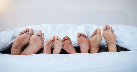 Image showing Family, feet in bed and in bedroom of their home with a lens flare sleeping together. Resting or barefoot, morning and parents with toes and children relaxing on holiday weekend break in their house