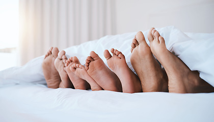 Image showing Family, feet in bed and in bedroom of their home with a lens flare sleeping together. Resting or barefoot, relaxing and parents with toes of their children comfortable in the morning of their house.