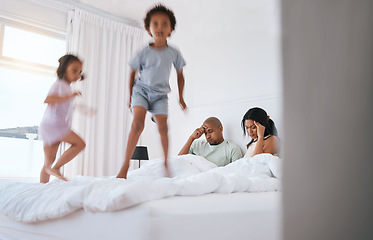 Image showing Young kids, jump and parents on bed with playing, game and excited in family house in morning. Naughty sibling children, mother and father in bedroom with bond, love and childhood development in home