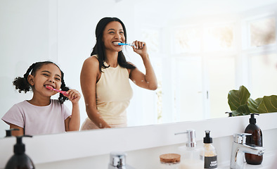 Image showing Brushing teeth, hygiene and a mother with her daughter in the bathroom of their home together for a morning routine. Kids, dental and toothbrush with a woman parent teaching her child about oral care