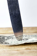 Image showing one American dollar pierced with a knife