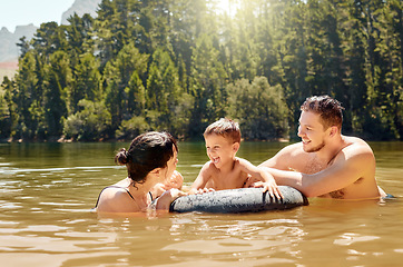 Image showing Parents, son and float on lake with inflatable, smile and excited for camping, vacation or swimming together. Man, woman and male child with happy family, holiday and tube on river in summer in woods