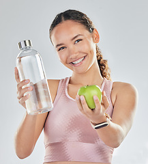 Image showing Portrait, woman and fitness with apple, water and in studio for diet of healthy food, nutrition and detox for wellness goals. Happy sports model, hydration or fruit to lose weight on white background