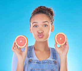 Image showing Portrait, kiss and woman with grapefruit in studio isolated on a blue background. Face, fruit and person with food for healthy diet, nutrition or wellness, eating and vitamin c, benefits and vegan.