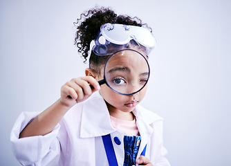 Image showing Child, magnifying glass and portrait of a scientist girl in studio with eye for scientific research. Face of a African kid student with magnifier for medical science, education or biology experiment