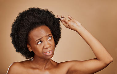 Image showing Worry, black woman and hair loss problem for afro in studio isolated on a brown background. Crisis, hairstyle and frustrated African model with split ends, frizz and damage in natural salon treatment