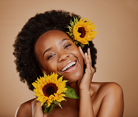 Image showing Portrait, aesthetic and sunflower with a model black woman in studio on brown background for beauty. Face, skincare or natural cosmetics and a happy young female person with a flower in her afro hair