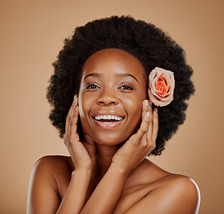 Image showing Happy, flower and portrait of a black woman with skincare, clean glow and wellness. Smile, touching face and an African model with floral beauty for skin isolated on a brown background in a studio