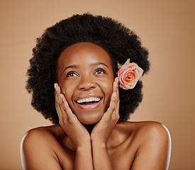 Image showing Face, black woman and skincare with rose for beauty in studio isolated on a brown background. Floral flower, excited and African model with natural cosmetics, thinking and organic facial treatment.