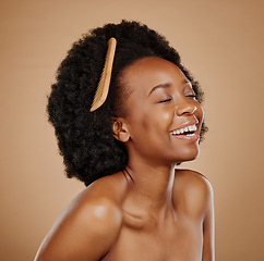 Image showing Hair, comb and a model black woman laughing in studio on a brown background for beauty or cosmetics. Funny, afro and haircare with an attractive young female person feeling excited for natural care