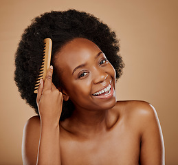 Image showing Black woman, portrait and hairstyle brush in studio, brown background and grooming of curly texture. Natural beauty, happy face and young african female model with comb tools for aesthetic hair care