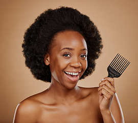 Image showing Portrait, hair and comb with a model black woman in studio on a brown background for beauty or cosmetics. Smile, afro and haircare with a happy young female person looking excited for natural care