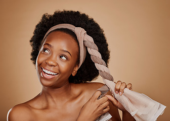 Image showing Happy, afro or black woman with headband thinking of change or beauty in studio on brown background. Tie, smile or thoughtful African girl model excited by haircare idea, scarf hairstyle or self love