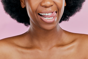 Image showing Black woman, mouth and tongue out, beauty and teeth with dental, health and hygiene on pink background. Lips, skin and African female model, oral care and grooming with healthy gums in studio