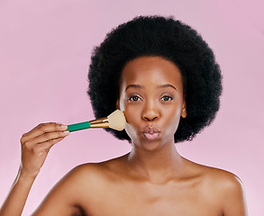 Image showing Face, makeup and black woman with brush, kiss and beauty in studio isolated on a pink background. Portrait, facial cosmetics and African model apply foundation, powder and wellness for skincare pout.