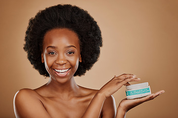 Image showing Portrait, hair and keratin product with a black woman in studio on a brown background for cosmetics. Face, smile and haircare treatment in the palm of a happy female model for natural afro hairstyle