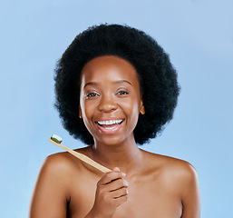 Image showing Bamboo toothbrush, face and black woman excited in studio isolated on a blue background. Portrait, toothpaste and model with natural, eco friendly or healthy wood, dental hygiene and cleaning teeth.