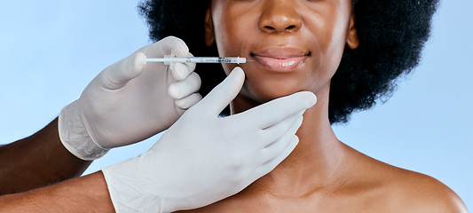 Image showing Black woman, face injection and beauty with lip filler, cosmetic procedure and dermatology on blue background. Liquid collagen, mouth and skincare with hands, female model and smile in portrait