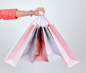 Image showing Fashion, studio or hand of woman with shopping bags for retail sale, product offer or discount deal. Choice, customer or girl shopper holding gift, package or present on promotion on white background