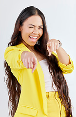 Image showing Portrait, pointing and wink with an excited woman in studio on a gray background to choose you. Smile, hands and selection with a happy young female model in yellow clothes to vote on a decision