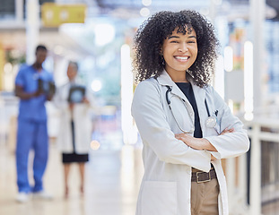 Image showing Portrait, happy doctor and confident woman in hospital for healthcare. Face, arms crossed and African medical professional, surgeon or physician with smile, wellness and pride for career with bokeh.