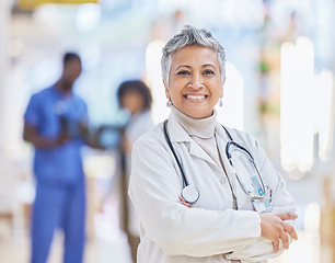 Image showing Doctor, portrait and senior woman with arms crossed in hospital for healthcare, wellness and pride for career. Face, confidence and elderly medical professional, surgeon or happy worker in clinic.