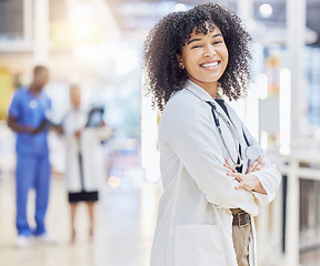 Image showing Portrait, happy doctor and woman with arms crossed in hospital for healthcare. Face, confidence and African medical professional, surgeon or clinic employee with smile, wellness and pride for career.