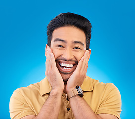 Image showing Happy, excited man and smile portrait in studio with Asian model with teeth and joy. Blue background, male person and casual fashion with handsome and friendly guy with modern style and wow face