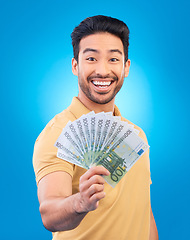 Image showing Happy man, portrait and money fan for bonus offer, financial success and winning, finance loan or cashback bonus. Young asian person or winner notes or cash profit isolated on studio blue background