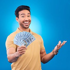 Image showing Money, studio and portrait of happy man excited for dollar bills, reward or bonus cash salary, giveaway or prize. Financial freedom, winner or person smile for income, revenue or blue background win