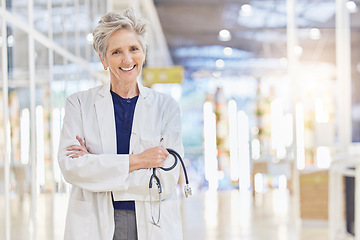 Image showing Doctor, portrait and senior woman with arms crossed, happy and bokeh in hospital. Elderly surgeon, face and confident medical professional, expert or healthcare worker with stethoscope for cardiology