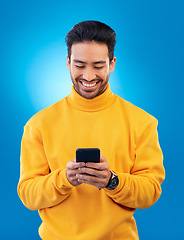 Image showing Phone, happy and young man or student for social media, college feedback or news, email and online chat. Networking, search and asian person for university info on mobile and studio, blue background