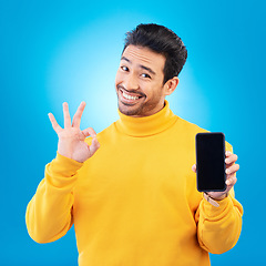 Image showing Advertising, portrait of a man with smartphone and okay or like sign in blue background happy for social networking. Online app or technology, marketing or branding and male person with cellphone