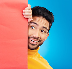 Image showing Surprise, peeking and young man in studio with a wow, omg or wtf facial expression by a board with mockup. Happy, shock and male model with sneaky face by poster with mock up space by blue background