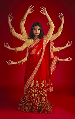 Image showing Indian woman, studio and culture with mudra, portrait and magic for culture, yoga and fashion by red background. Girl, model and beauty for fantasy, jewellery and art with clothes for festive event