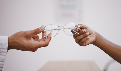 Image showing Hands, vision or glasses with an optometrist and customer in an eyewear store closeup for prescription lenses. Healthcare, medical and optometry with a optician giving frame spectacles to a client