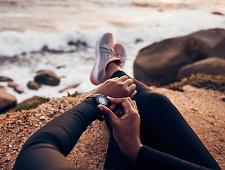 Image showing Relax, check and smart watch with hand of woman on rock for running, fitness tracker and heart rate. Workout, exercise and goal with closeup of female runner at beach for monitor, goals and time