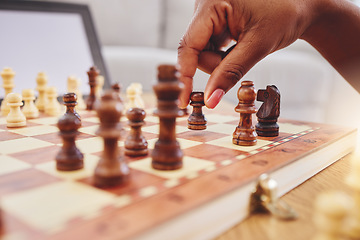 Image showing Chess, move and closeup of hand with board piece for strategy, thinking and challenge on table. Competition, planning and zoom of hands of person with chessboard in living room for problem solving