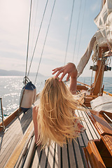 Image showing Back, travel and a woman on a yacht for a luxury cruise at sea during summer for a vacation or holiday. Water, view and horizon with a female tourist or traveler sitting on a boat in the ocean