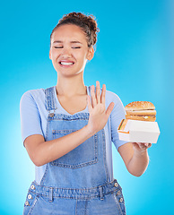 Image showing Burger, no and woman reject fast food choice and unhappy gives bad, disgust and frustrated review for diet protection. Disaster, mistake and person disappointed isolated in a studio blue background