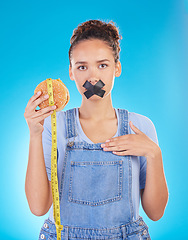 Image showing Burger, diet and woman tape mouth for fast food and weight loss gives bad, disgust and frustrated review for protection. Disaster, mistake and person disappointed isolated in a studio blue background